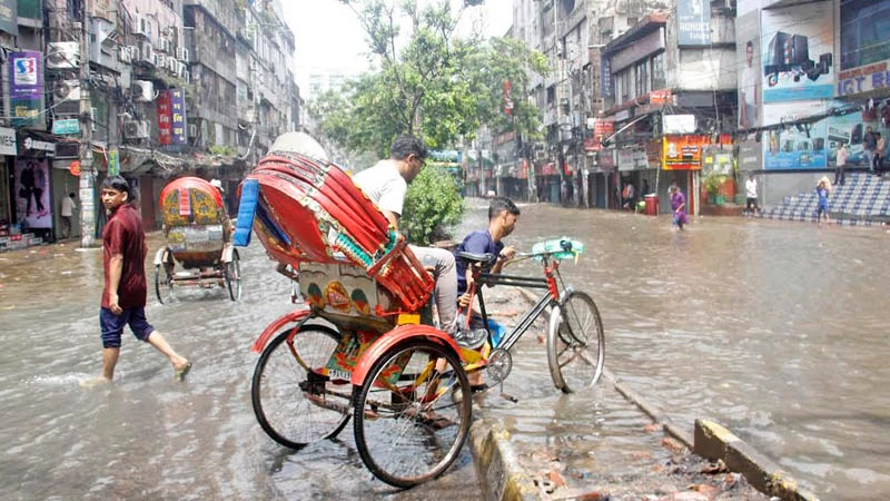 জলাবদ্ধ এলিফ্যান্ট রোডে গন্তব্যের দৈর্ঘ্য কমাতে সড়কদ্বীপের ওপর দিয়ে পার হচ্ছে রিকশা। ছবি: ফোকাস বাংলা 