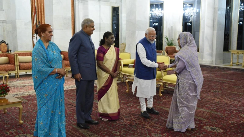 ভারতীয় প্রধানমন্ত্রী নরেন্দ্র মোদির সঙ্গে শুভেচ্ছা বিনিময় করছেন প্রধানমন্ত্রী শেখ হাসিনা। সেসময ভারতীয় রাষ্ট্রপতি দৌপর্দী মুর্মুও উপস্থিত ছিলেন