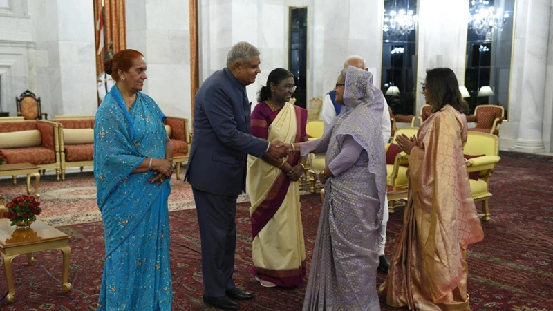 ভারতীয় প্রধানমন্ত্রী নরেন্দ্র মোদির সঙ্গে শুভেচ্ছা বিনিময় করছেন প্রধানমন্ত্রী শেখ হাসিনা। সেসময ভারতীয় রাষ্ট্রপতি দৌপর্দী মুর্মুও উপস্থিত ছিলেন